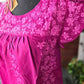 Hot pink ruffled blouse with flower appliqué