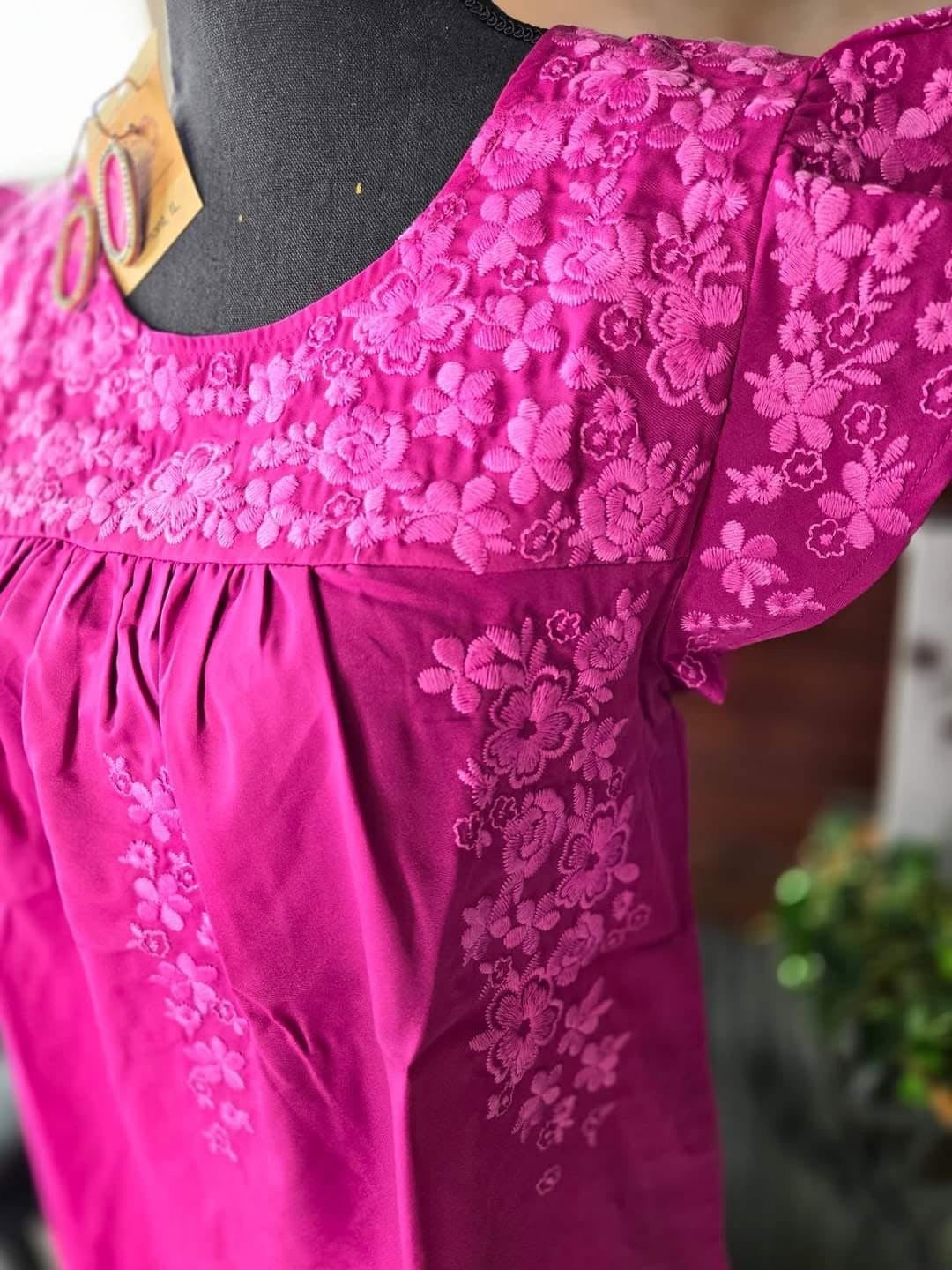 Hot pink ruffled blouse with flower appliqué