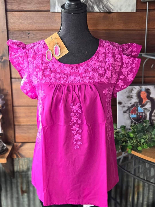 Hot pink ruffled blouse with flower appliqué